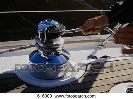 A person winding rope around a crank on a yacht View Large Photo Image Stock Photo - A person winding rope around a crank on a yacht. Fotosearch