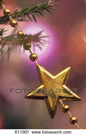 Stock Photo - A star hanging on a Christmas tree. Fotosearch
