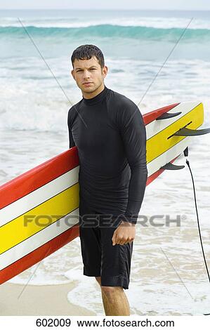 A surfer carrying his surfboard View Large Photo Image Stock Photo - A surfer carrying his surfboard. Fotosearch