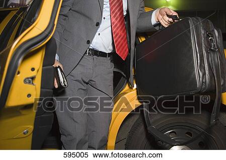 Midsection of a businessman leaving a taxi View Large Photo Image Stock Photography - Midsection of a businessman leaving a taxi. Fotosearch