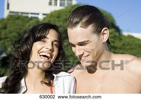 Two young people laughing outdoors View Large Photo Image Stock Image - Two young people laughing outdoors. Fotosearch