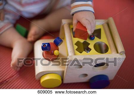 Stock Photography - A baby playing with toys. Fotosearch