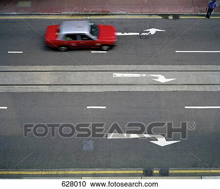 Stock Image - A car driving along a street. Fotosearch
