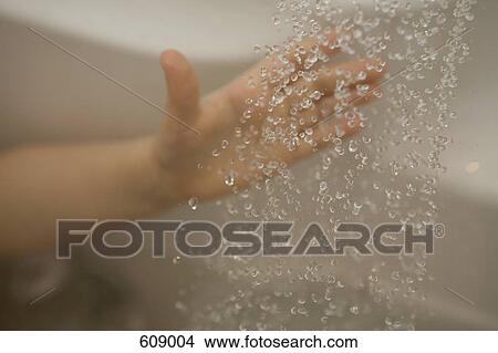 A hand reaching out to falling water View Large Photo Image Picture - A hand reaching out to falling water. Fotosearch