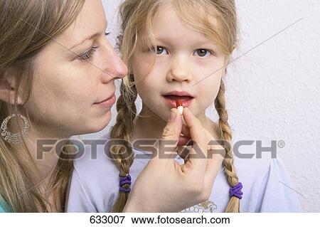 A mother giving her daughter a pill View Large Photo Image Stock Photo - A mother giving her daughter a pill. Fotosearch
