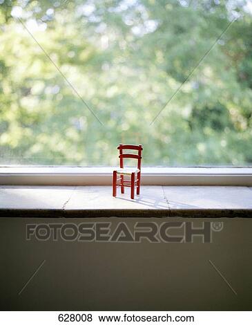 A small chair on a window sill View Large Photo Image Stock Photo - A small chair on a window sill. Fotosearch