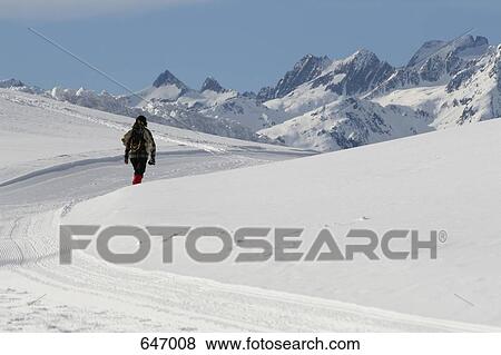 Stock Photo - A woman walking in the mountains, Graubuenden, Switzerland. Fotosearch