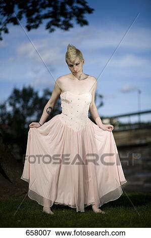 A young punk woman in an evening gown standing in a park View Large Photo Image Stock Photo - A young punk woman in an evening gown standing in a park. Fotosearch