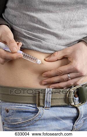A young woman injecting herself in the abdomen View Large Photo Image Picture - A young woman injecting herself in the abdomen. Fotosearch