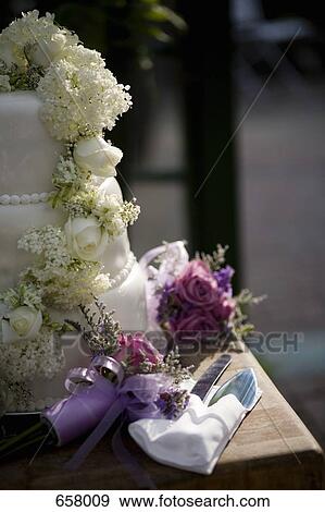 Close up of a wedding cake, floral bouquets and wedding cake serving set View Large Photo Image Stock Photo - Close up of a wedding cake, floral bouquets and wedding cake serving set. Fotosearch