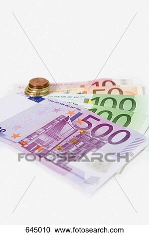 Stock Image - European Currency banknotes fanned out and a stack of European union coins. Fotosearch
