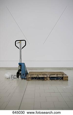 Stock Image - Hand powered pallet truck with an empty pallet. Fotosearch
