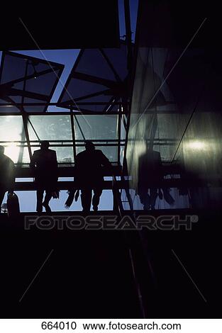 Stock Image - Rear view silhouette of two people walking up stairs. Fotosearch