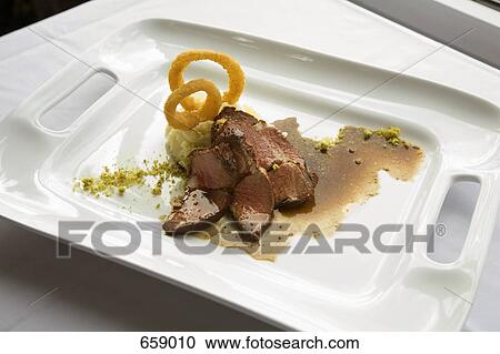 Stock Image - Roast Beef, garlic mashed potatoes and onion ring garnish. Fotosearch