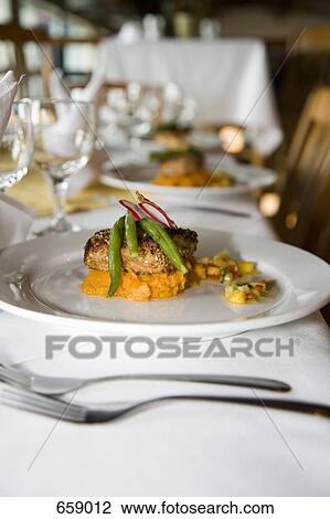 Stock Image - Tuna steak served on butternut squash and garnished with green beans and radish. Fotosearch