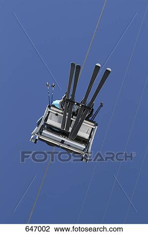 Two skiers sitting on a ski lift View Large Photo Image Stock Image - Two skiers sitting on a ski lift. Fotosearch