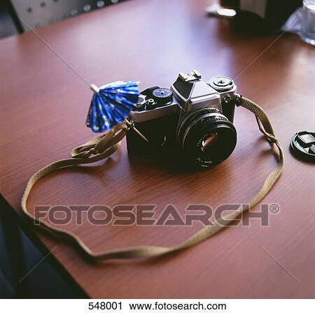 A camera on a desk with a drink umbrella View Large Photo Image Stock Image - A camera on a desk with a drink umbrella. Fotosearch