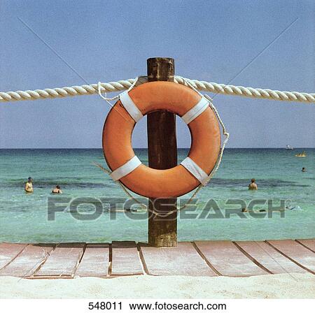 A life preserver hanging on a dock handrail and people swimming in the background View Large Photo Image Stock Image - A life preserver hanging on a dock handrail and people swimming in the background. Fotosearch
