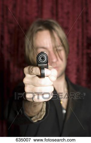 A man aiming a gun View Large Photo Image Stock Photo - A man aiming a gun. Fotosearch