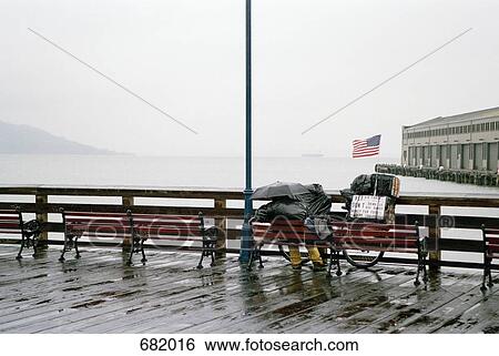 A person sitting on a bench in the rain, overlooking San Francisco Bay, USA View Large Photo Image Stock Photograph - A person sitting on a bench in the rain, overlooking San Francisco Bay, USA. Fotosearch