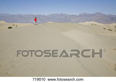A person walking along a sand dune, Death Valley, California, USA View Large Photo Image Stock Image - A person walking along a sand dune, Death Valley, California, USA. Fotosearch