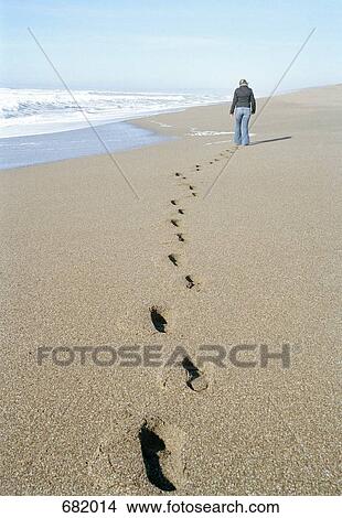 A woman walking along the beach View Large Photo Image Picture - A woman walking along the beach. Fotosearch