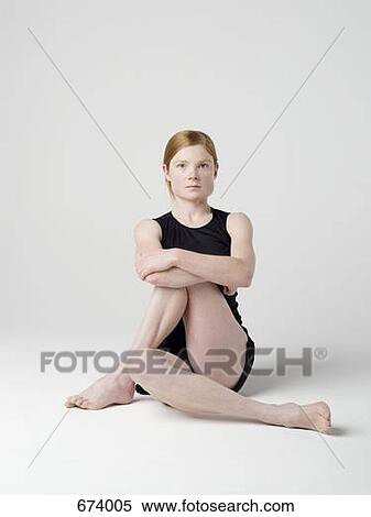 A young woman beginning the 'Half Spinal Twist' yoga pose View Large Photo Image Stock Photography - A young woman beginning the 'Half Spinal Twist' yoga pose. Fotosearch