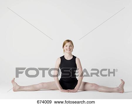 A young woman beginning the 'Spread Leg Forward Fold' yoga pose View Large Photo Image Stock Photo - A young woman beginning the 'Spread Leg Forward Fold' yoga pose. Fotosearch