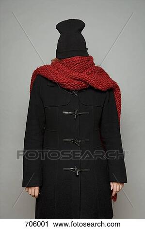 Stock Image - A young woman bundled up in a scarf, winter jacket and knit cap. Fotosearch