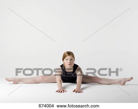 A young woman practicing the 'Spread Leg Forward Fold' yoga pose View Large Photo Image Picture - A young woman practicing the 'Spread Leg Forward Fold' yoga pose. Fotosearch