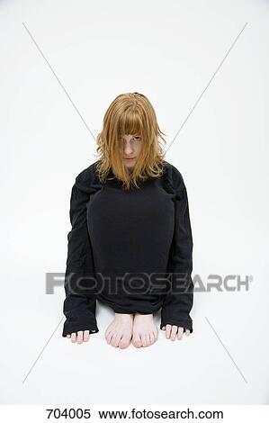 A young woman with her legs tucked in View Large Photo Image Stock Photography - A young woman with her legs tucked in. Fotosearch