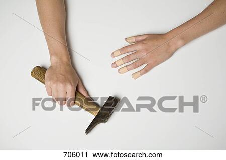 A young woman with plasters on all fingers of one hand and in the other hand is a hammer View Large Photo Image Stock Image - A young woman with plasters on all fingers of one hand and in the other hand is a hammer. Fotosearch