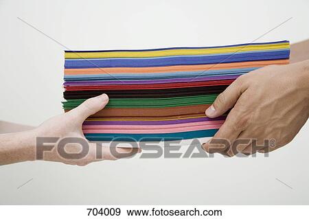 Human hands exchanging stack of multi colored paper View Large Photo Image Stock Photo - Human hands exchanging stack of multi colored paper. Fotosearch