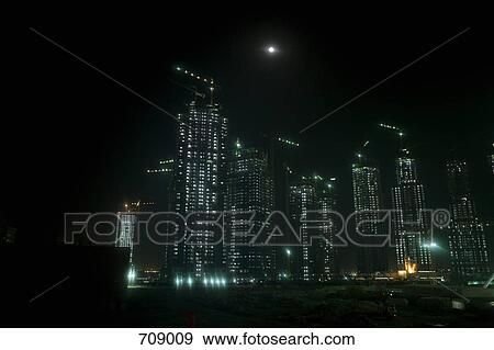 Skyscrapers being constructed at night, Dubai, UAE View Large Photo Image Stock Photo - Skyscrapers being constructed at night, Dubai, UAE. Fotosearch