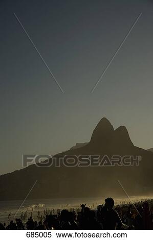 Stock Photography - The shadow of Dois Irmaos (Two Brothers) Mountain on Ipanema Beach, backlit. Fotosearch