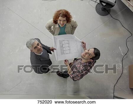 A building contractor going over blueprints with a young couple View Large Photo Image Stock Image - A building contractor going over blueprints with a young couple. Fotosearch