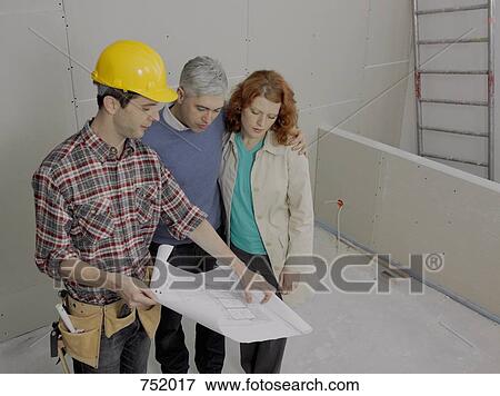 A building contractor going over blueprints with a young couple View Large Photo Image Stock Photo - A building contractor going over blueprints with a young couple. Fotosearch