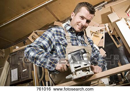 A carpenter using a sanding machine in a workshop View Large Photo Image Stock Photograph - A carpenter using a sanding machine in a workshop. Fotosearch