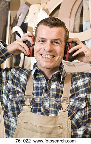 Stock Image - A carpenter with ear protectors. Fotosearch