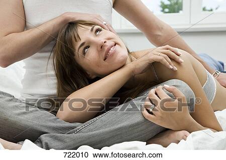 Stock Image - A couple embracing on a bed. Fotosearch
