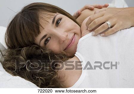 Stock Image - A couple lying down and embracing. Fotosearch