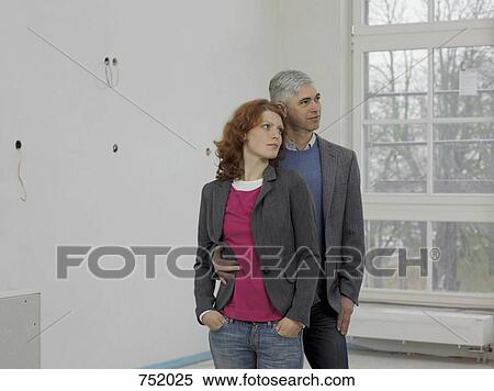 A couple standing in a their new home View Large Photo Image Stock Photography - A couple standing in a their new home. Fotosearch
