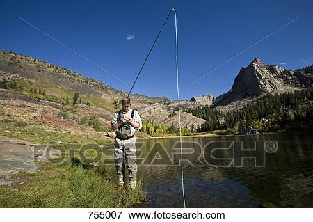 A fisherman tying flies next to a lake View Large Photo Image Stock Photo - A fisherman tying flies next to a lake. Fotosearch