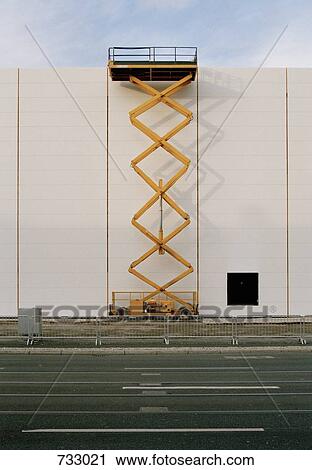 A hydraulic platform raised next to a building View Large Photo Image Stock Image - A hydraulic platform raised next to a building. Fotosearch