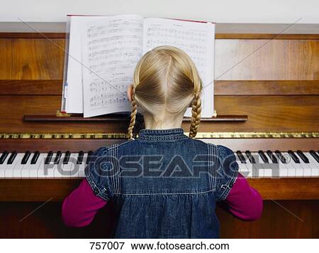 A little girl playing a piano, rear view, portrait View Large Photo Image Stock Photo - A little girl playing a piano, rear view, portrait. Fotosearch
