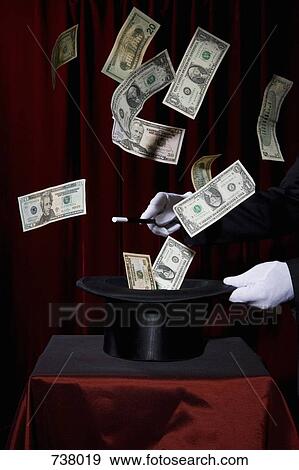 A magician performing magic by making money come out of a hat View Large Photo Image Stock Photo - A magician performing magic by making money come out of a hat. Fotosearch