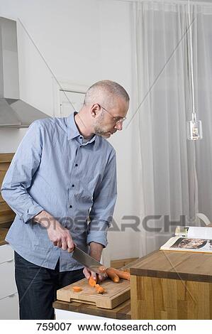 A man about to slice his finger while slicing carrots View Large Photo Image Stock Photo - A man about to slice his finger while slicing carrots. Fotosearch