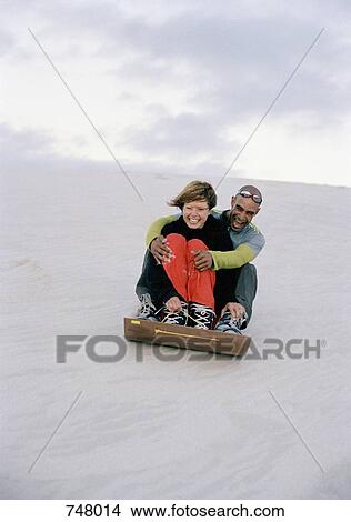 A man and a woman sliding down a sand dune View Large Photo Image Picture - A man and a woman sliding down a sand dune. Fotosearch