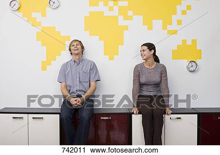 A man and a woman taking a break in an office View Large Photo Image Stock Image - A man and a woman taking a break in an office. Fotosearch