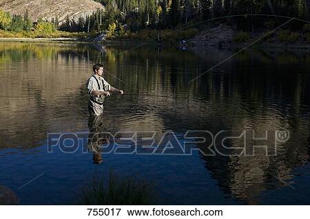 A man fly fishing in a lake View Large Photo Image Stock Photo - A man fly fishing in a lake. Fotosearch